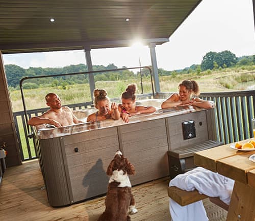 Holidaymakers enjoying hot tub as dog looks on