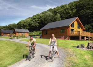 Couple enjoying bike ride outside lodges in summer