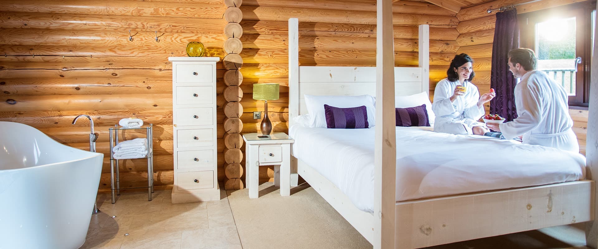 Couple relaxing on bed in log cabin