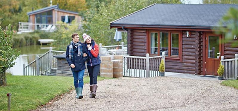 Couple enjoying autumn walk outside their log cabin