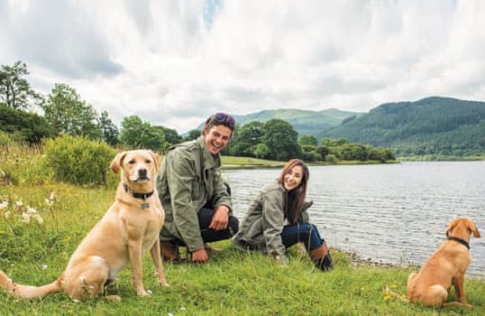 Young couple enjoying a walk with the dogs
